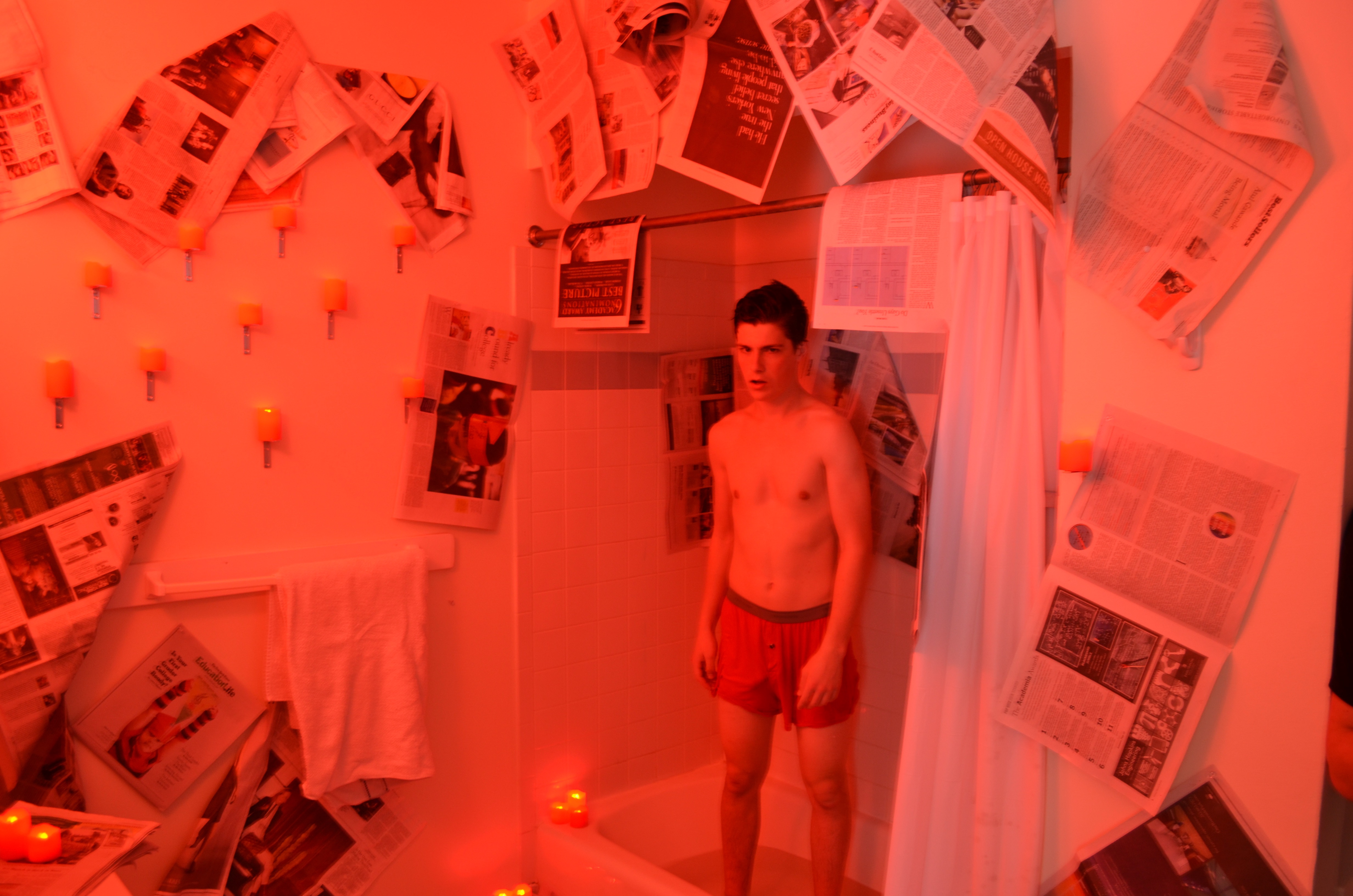 A bathroom sealed in newsprint and lit hard red